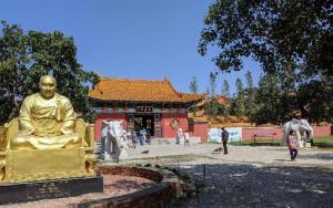 A golden Buddha in front of an oriental temple